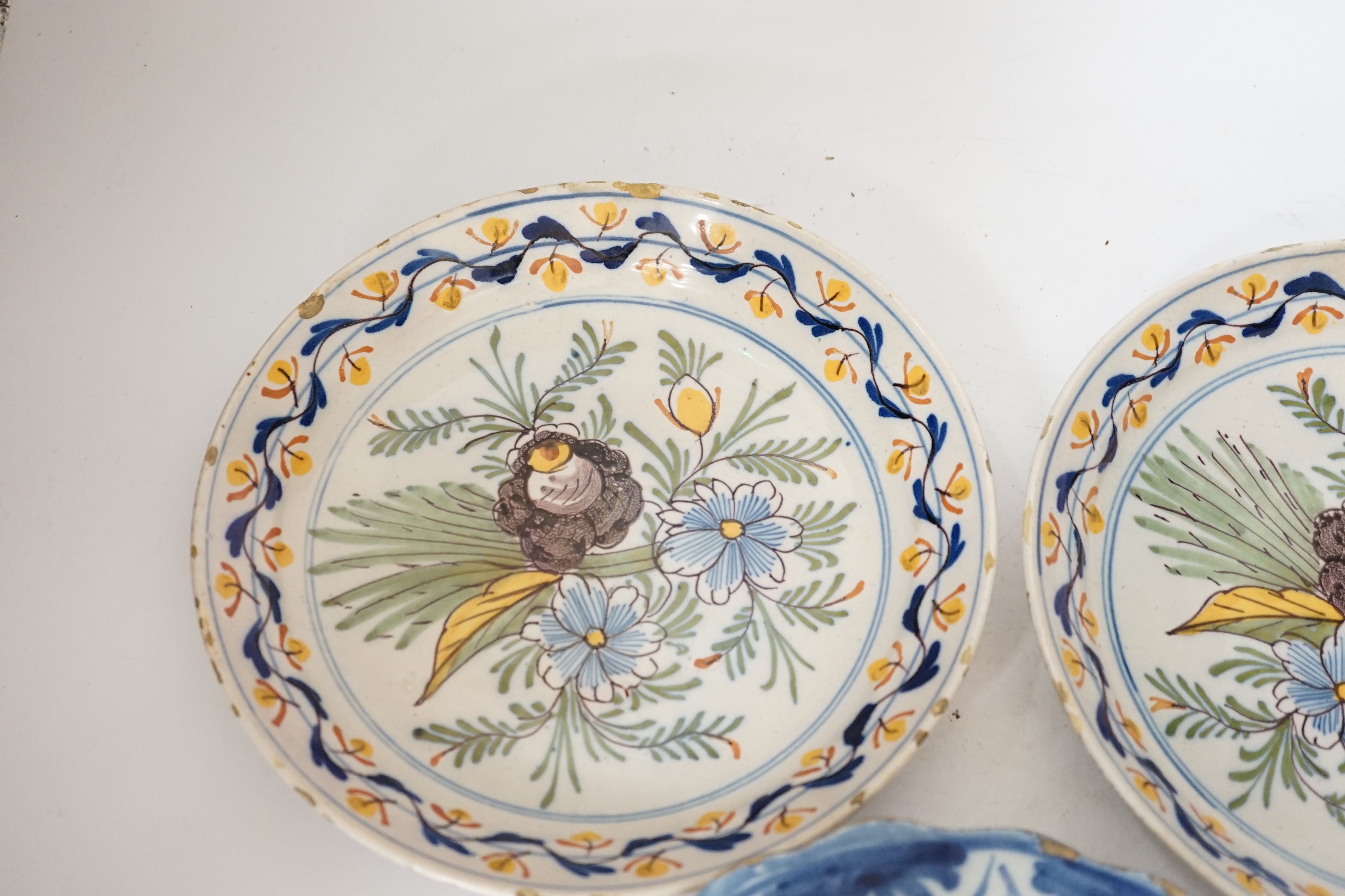 A Delft blue and white dish, c.1700 and two 18th century Delft polychrome dishes, 22cm (3)